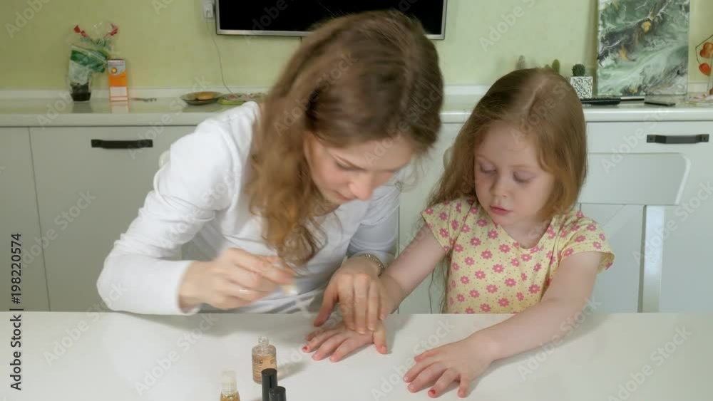 Mother and daughter having fun painting fingernails, family time concept Mother and daughter having fun painting fingernails, family time concept