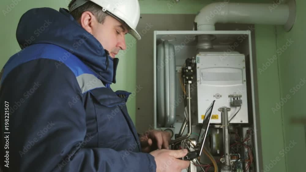 Worker checking gas-fire boiler Worker checking gas-fire boiler