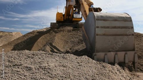 Excavator is preparing pile of sand for loading in truck on building site
Yellow excavator is making pile of soil by pulling ground up on heap at construction site, project in progress.

