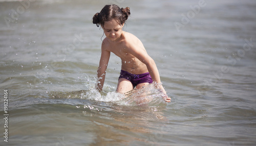 Little girl swims and plays in the sea photo