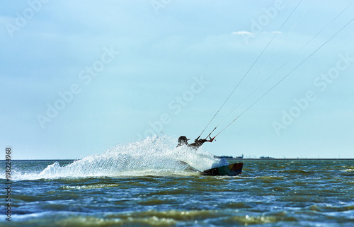 Man riding a kite surfing on the waves in the summer. © trek6500