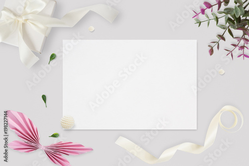 Styled stock photo. Feminine wedding desktop mockup. White roses, satin ribbon, beads on delicate beige background. Copy space. Top view. Picture for blog.