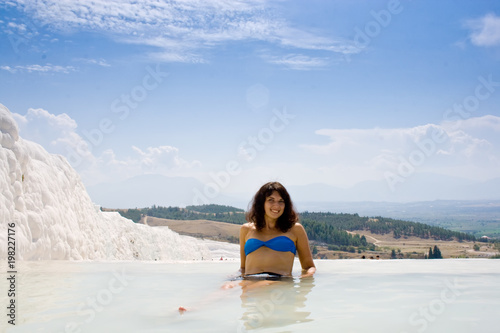 Beautiful female tourist in blue swimsuit and shorts in Pamukkale, Turkey