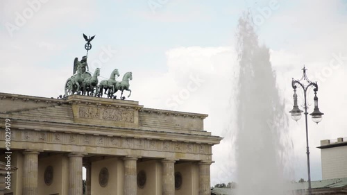 Famous tourist attraction in Berlin - Brandenburg Gate. A fountain and a street lamp. A summer day. Real time locked down medium shot photo