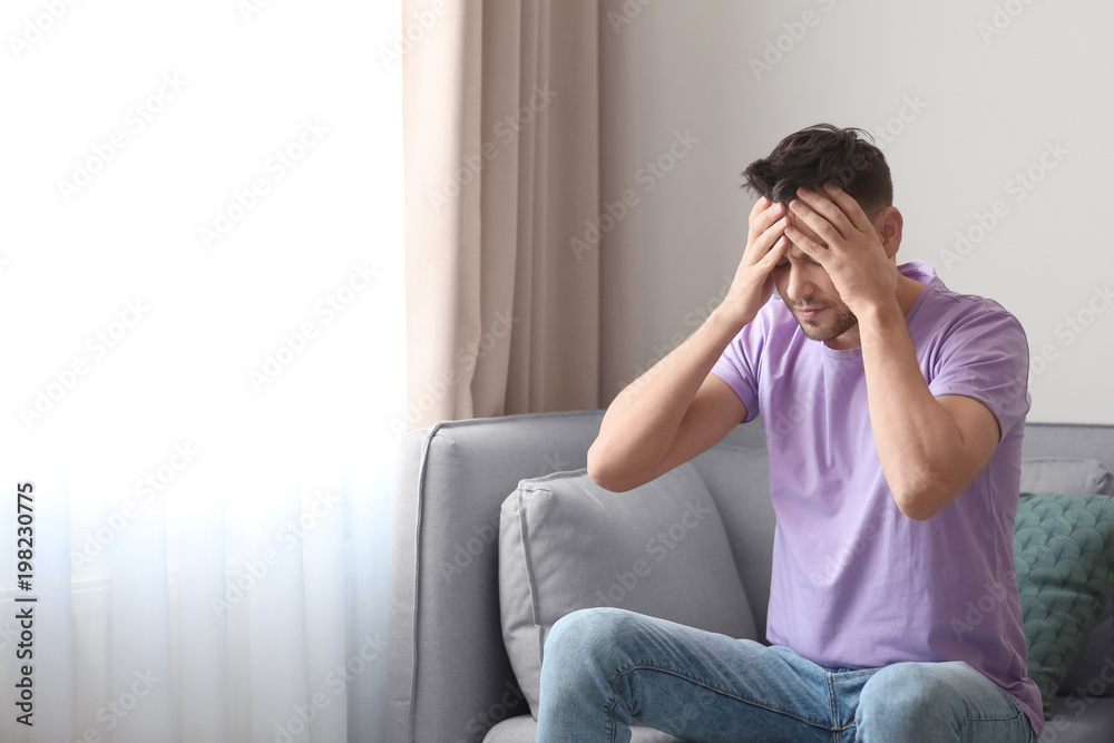 Young man suffering from headache at home Young man suffering from headache at home