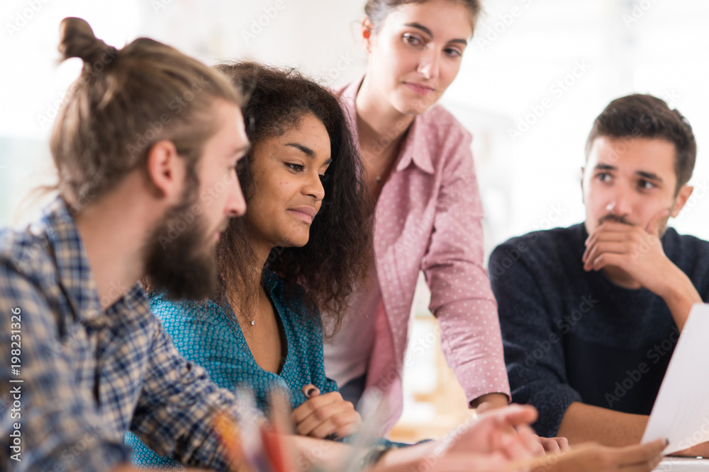 Young multiethnic creative team sharing ideas on a project Young multiethnic creative team sharing ideas on a project