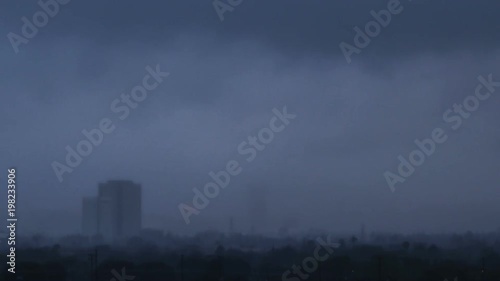 Dark rainstorm passing through city - time lapse