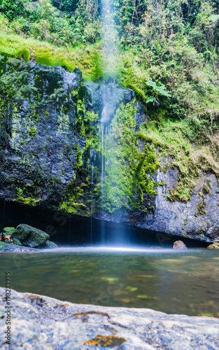 Long exposure of crystal clear water flowing down, vertical view photo