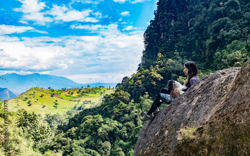 Woman and her dog contemplating the horizon on a rock, second photo