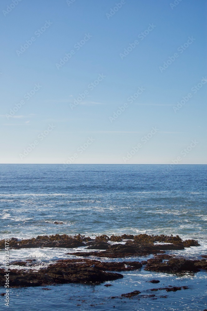 Beautiful scenic coastal view in California (USA): Untouched nature of the pacific ocean with limestone rock cliffs and crashing waves with a clear blue summer sky create the perfect picturesque place Beautiful scenic coastal view in California (USA): Untouched nature of the pacific ocean with limestone rock cliffs and crashing waves with a clear blue summer sky create the perfect picturesque place