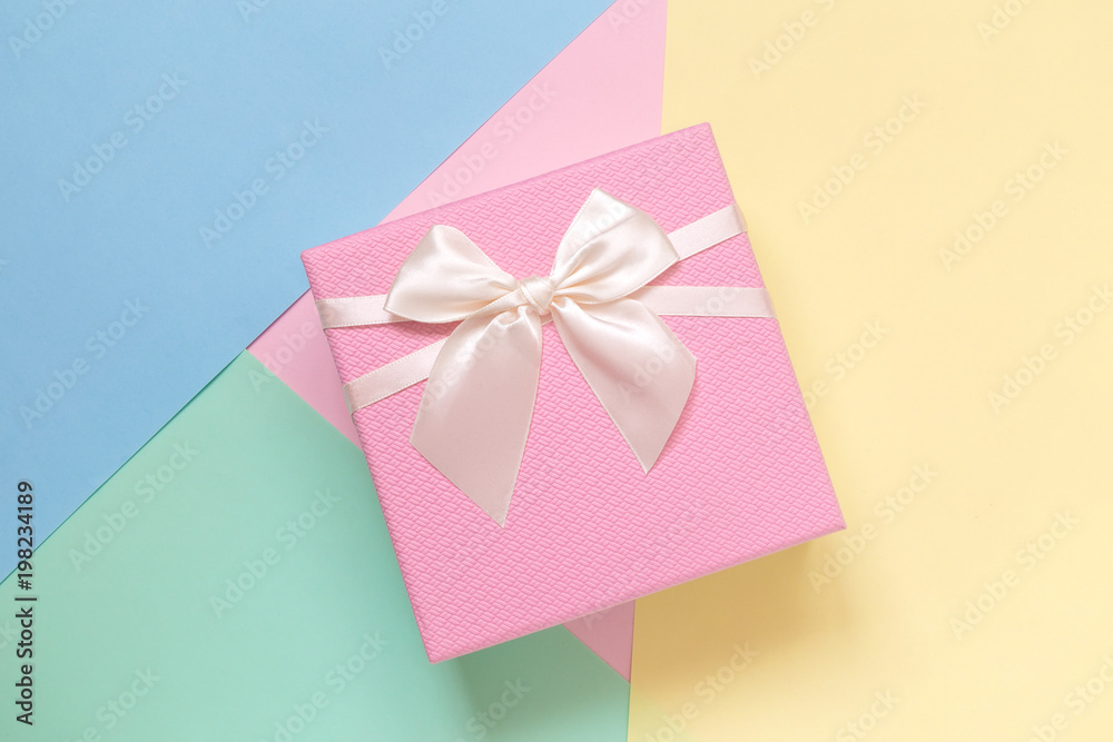 Flat lay of pastel pink present on multicolored pastel background minimalistic concept Flat lay of pastel pink present on multicolored pastel background minimalistic concept