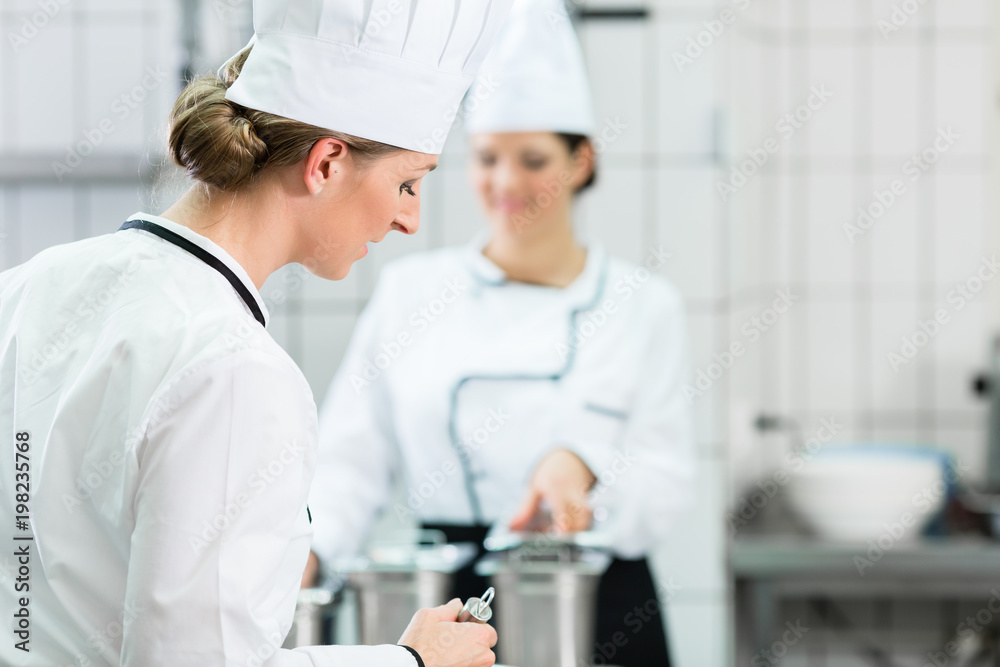 Female chefs at work in industrial kitchen of canteen 