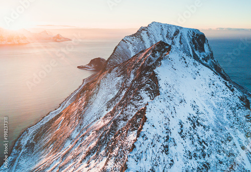 Norwegian winter sunny mountain landscape blue sky view with mountains, fjord, Norway, Ryten peak - famous mountain in Lofoten Islands, Moskenes municipality, Nordland, shot from drone photo