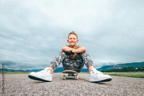 Boy sits on skate board