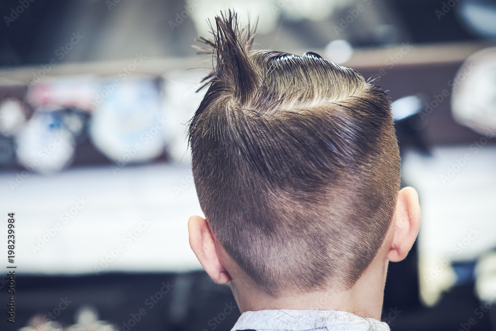 Boy getting a hairstyling in barbershop. Boy getting a hairstyling in barbershop.