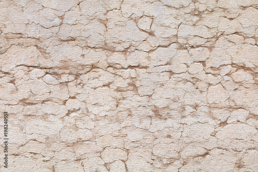 rissige Natursteinmauer hellrosa mit Fissuren