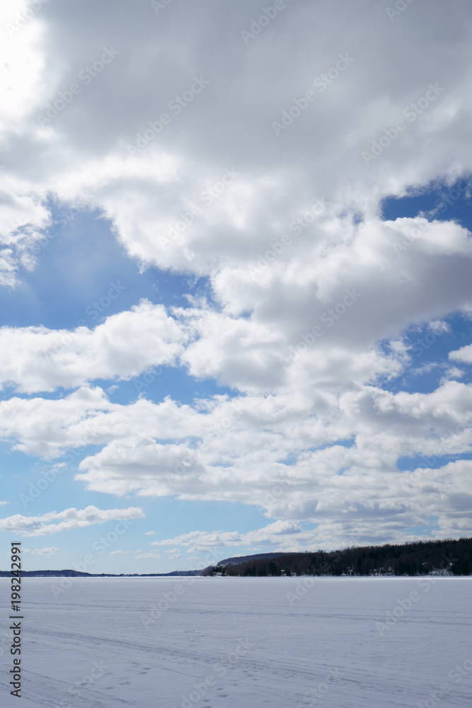 Large blue sky with white clouds on the lake at spring time during a beautiful day.