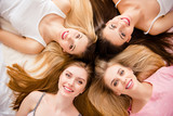 Close up portrait of sexy, pretty, crazy, sweet, charming, funny, foolish, blonde, brunette, lovely, cheerful girls lying head to head on bed looking at camera