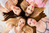 Portrait of sexy, pretty, brunette, blonde, sweet, charming, funny, foolish, lovely, cheerful girls lying head to head on bed looking at camera, sending, blowing kiss with pout lips