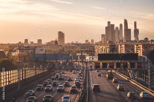 Summer evening cityscape photography of Moscow city with car traffic and amazing sunset above wide road with many cars and modern skyscrapers  Russia outdoor landscape