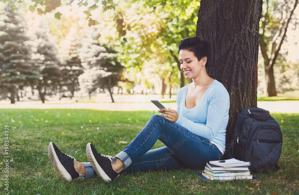 Smiling woman typing on mobile outdoors Smiling woman typing on mobile outdoors