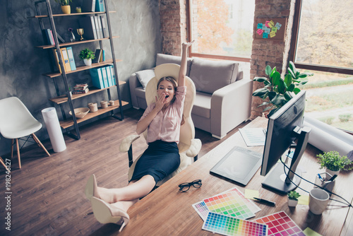Fotografie Pretty, attractive, drowsy, somnolent woman putting legs on desk, stretch hersel
