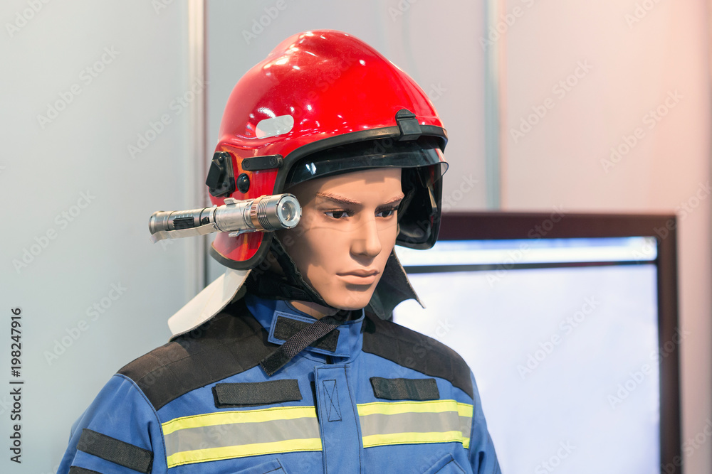 Exhibition firefighter dummy in fire fighter helmet and uniform. Protective  rescue wear. Head light torch foto de Stock | Adobe Stock