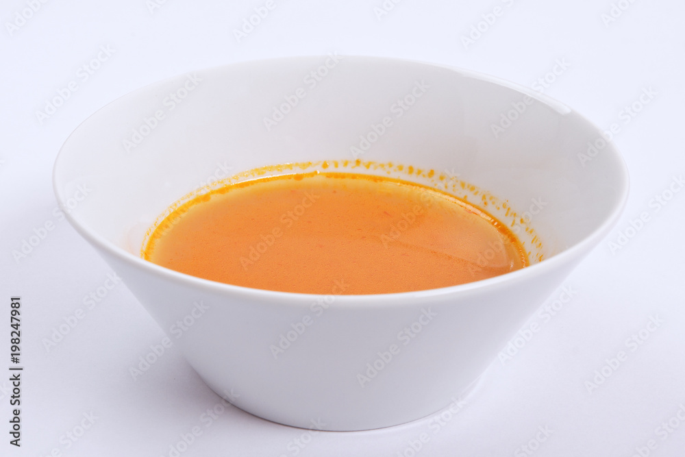 Pumpkin soup with tomatoes on a white Pumpkin soup with tomatoes on a white