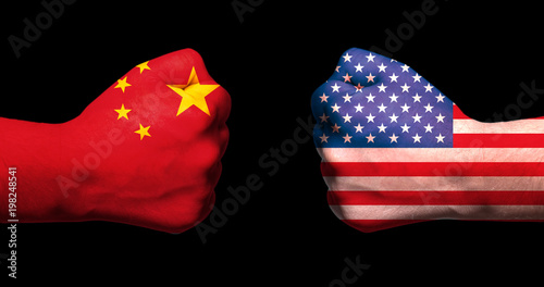 Photography Flags of USA and China on two clenched fists facing each other on black backgrou