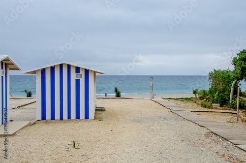 Blue striped beach hut in the sand