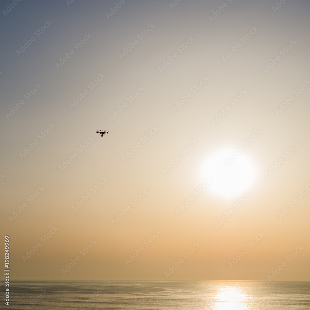 Drone flight over the sea with sun as background