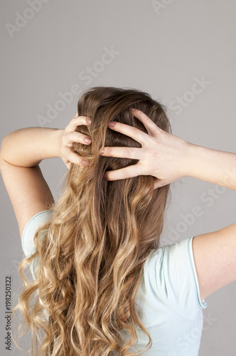 A young girl from the back with a strong headache. Convulsive spasm and headaches concept.