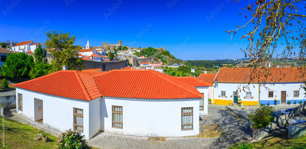 Panoramic view of the beautiful medieval historic center village of Obidos and Castle of Obidos. Wonderful romantic afternoon landscape at sunny weather. District of Leiria, in the centre of Portugal.