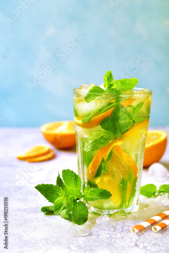 Homemade orange lemonade with mint in a tall glass.
