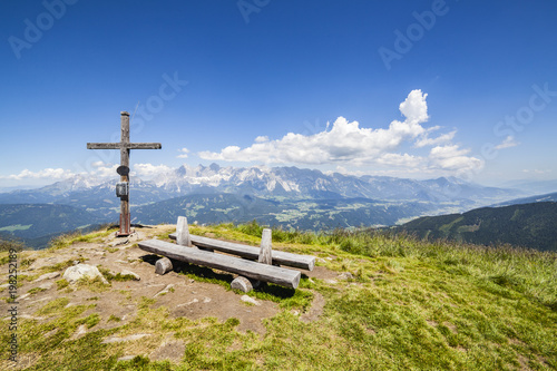 View from mountain Gasselhoehe with wooden bench to mountain Dachstein photo