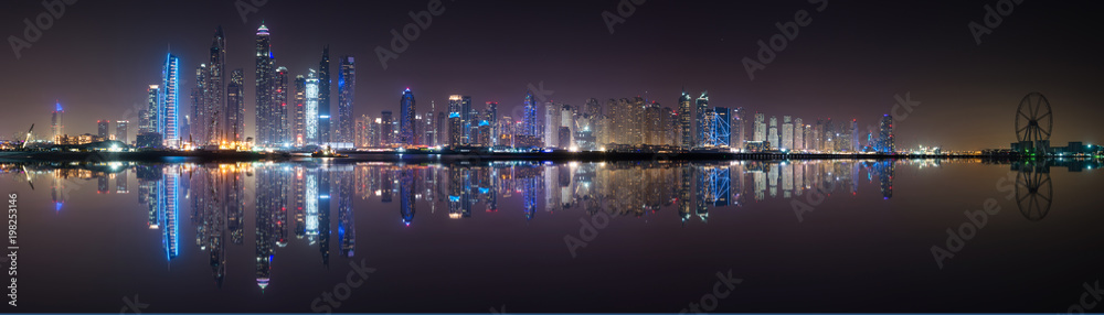 Panoramic view of Dubai Marina skyline with reflection at night, UAE
