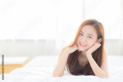 Beautiful portrait young asian woman lying and smile while wake up with sunrise at morning, lifestyle and relax concept. © N_studio