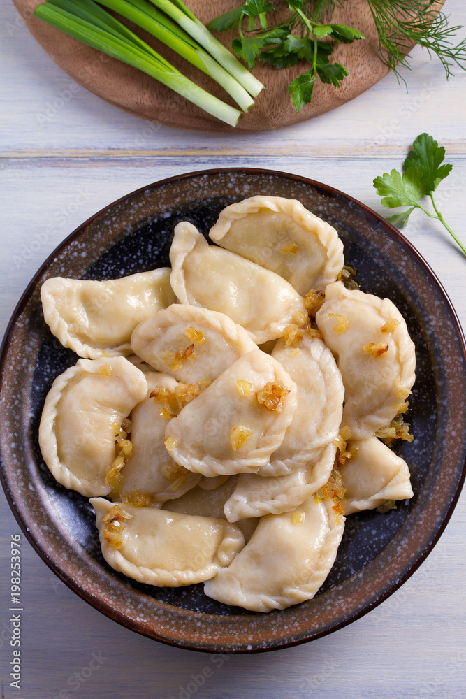 Plate of pierogi or varenyky, vareniki, Dumplings, filled with potato. Pyrohy - dumplings with filling. View from above, top, overhead
