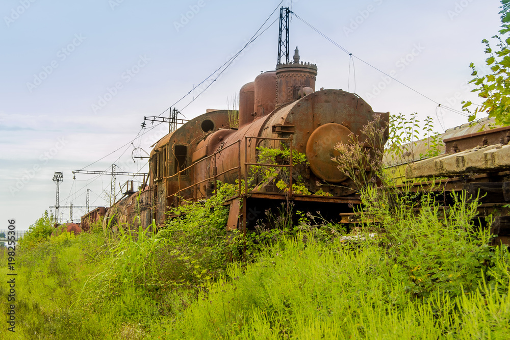 Abandoned train. Abandoned railway. Old rusty steam locomotive overgrown by plants Abandoned train. Abandoned railway. Old rusty steam locomotive overgrown by plants