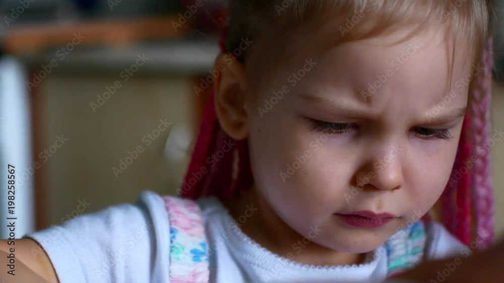 Little girl makes a expressive grimace and looking forward Little girl makes a expressive grimace and looking forward