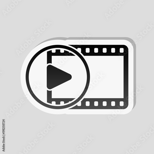 movie strip with play symbol in circle. simple silhouette. Sticker style with white border and simple shadow on gray background