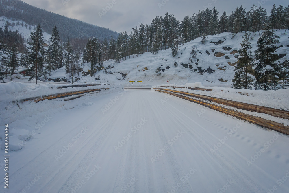 Outdoor view of winter road snow and ice in the forest of Norway Outdoor view of winter road snow and ice in the forest of Norway