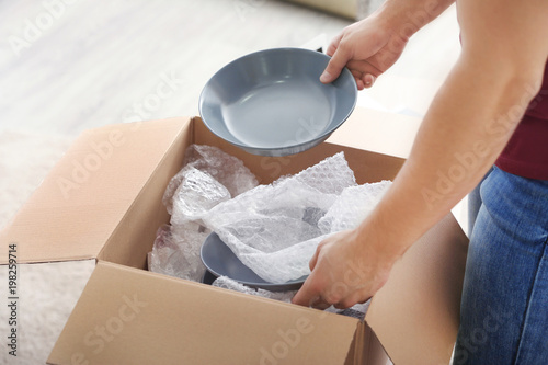 Young man unpacking parcel at home photo