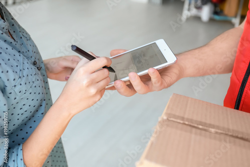 Woman signing on tablet for...