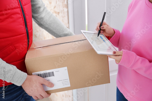 Woman signing on tablet for...