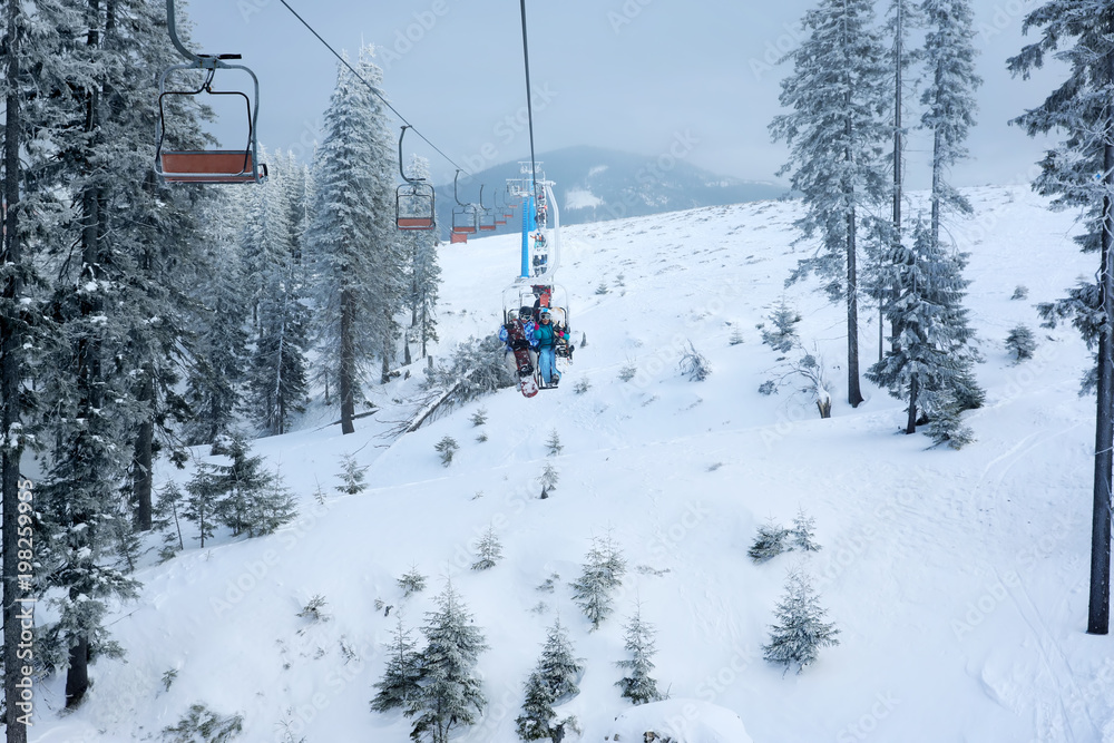 Couple on ski lift at mountain resort. Winter vacation Couple on ski lift at mountain resort. Winter vacation