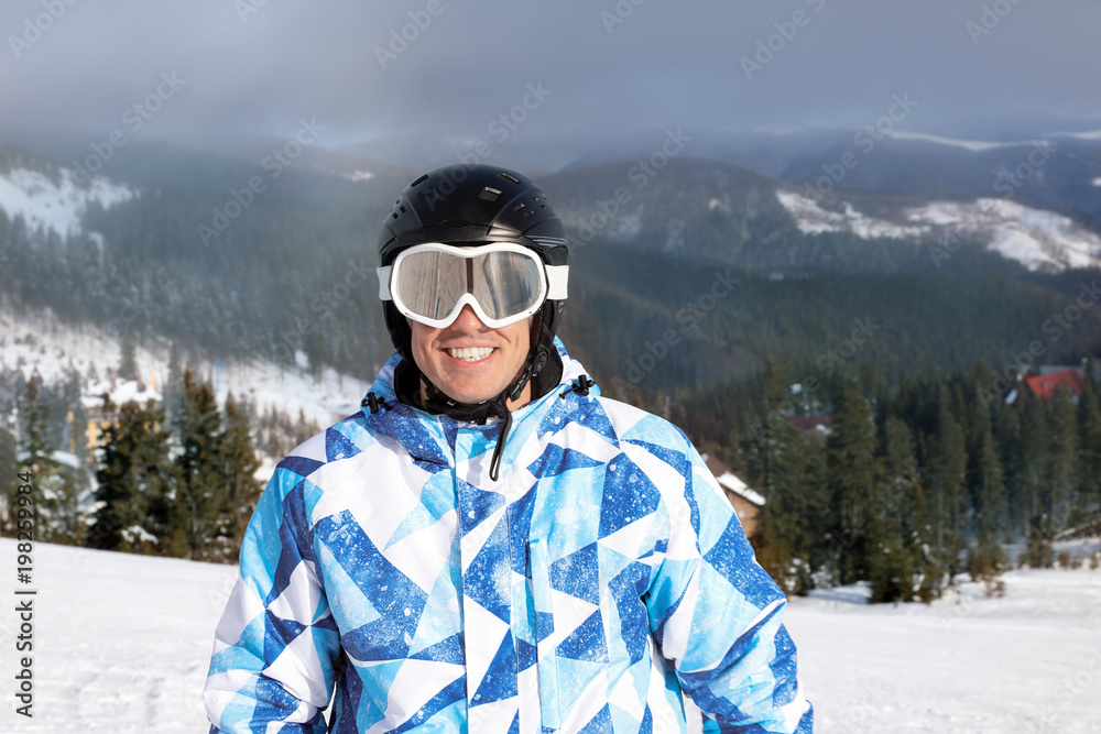 Portrait of happy man at snowy ski resort. Winter vacation