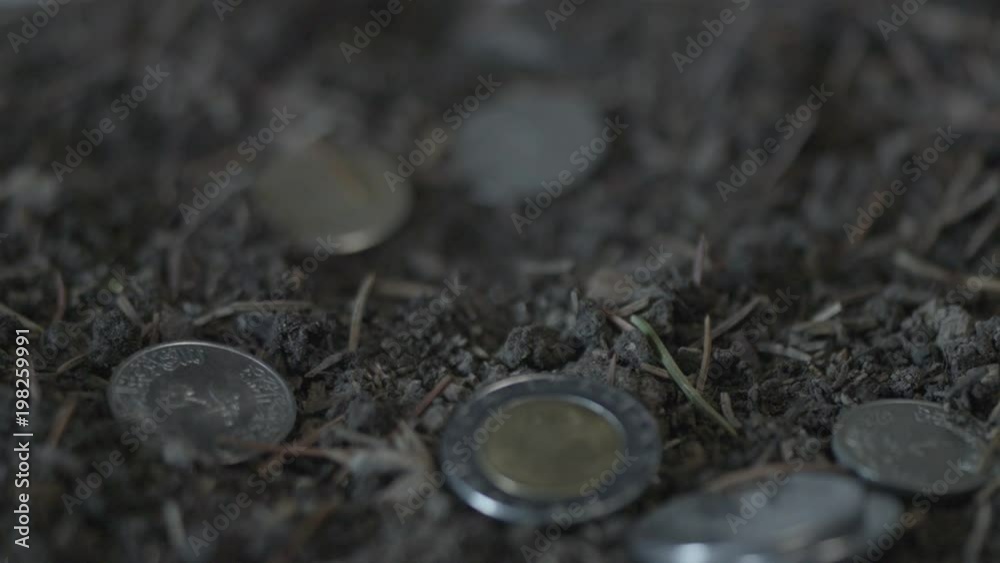Slow motion shot of coins falling into dirt. Shot for an Easter short film Slow motion shot of coins falling into dirt. Shot for an Easter short film