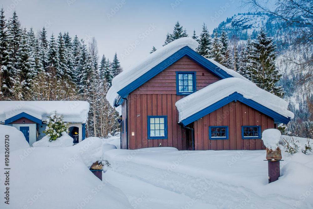 View of traditional wooden houses covered with snow in stunning nature background in Norway View of traditional wooden houses covered with snow in stunning nature background in Norway