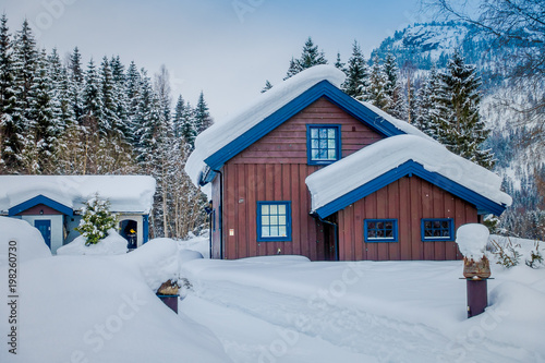 View of traditional wooden houses covered with snow in stunning nature background in Norway photo